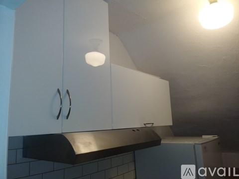 A kitchen with white cabinets and a black counter.