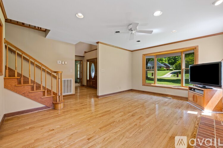 A living room with a television and a staircase.