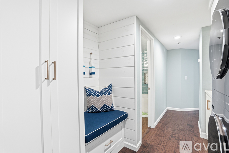 A small bedroom with a bed and a washing machine.