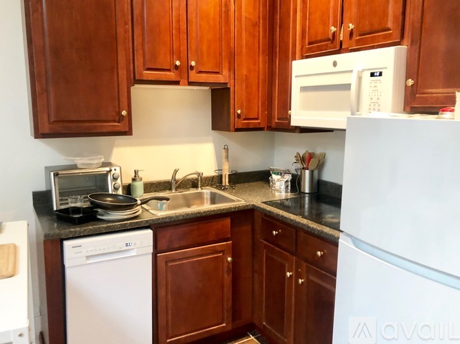 A kitchen with brown cabinets and a white refrigerator.