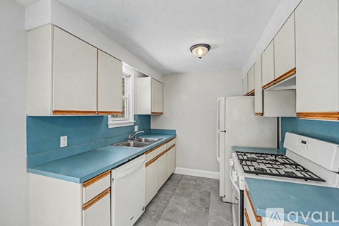A kitchen with white cabinets and a blue counter.