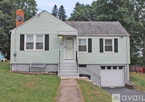 A house with a green siding and a white door is for sale.
