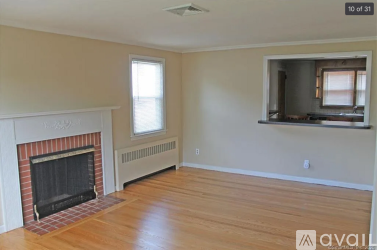 A living room with a fireplace and a window.