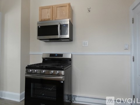 A black stove and microwave are installed above a black oven in a kitchen.
