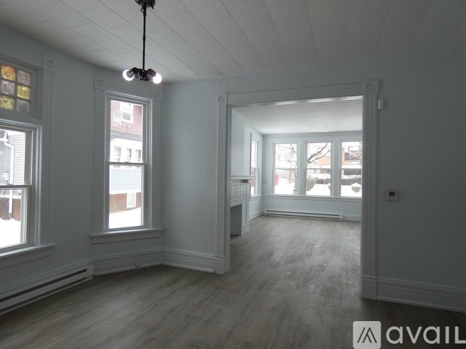 A spacious room with a large window and a fireplace.