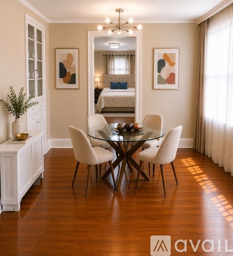 A dining room with a glass table and white chairs.