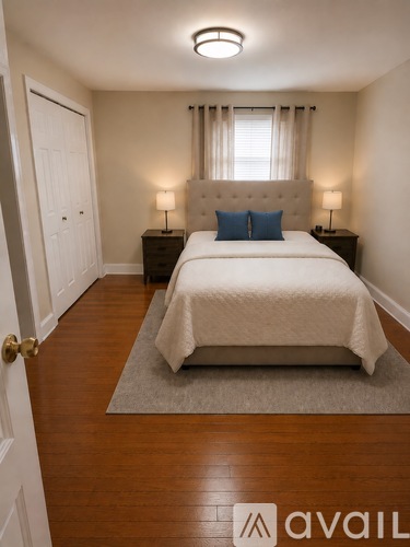 A bedroom with a bed, nightstands, and a rug.