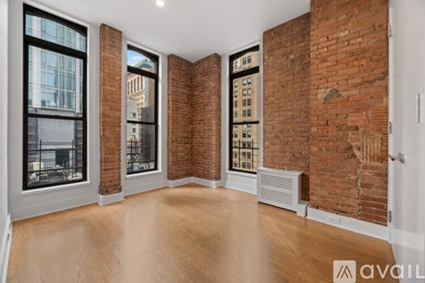 A room with wooden floors and a brick wall.