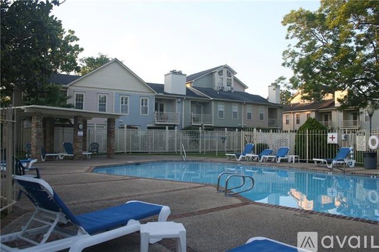 A pool surrounded by chairs and a house in the background.