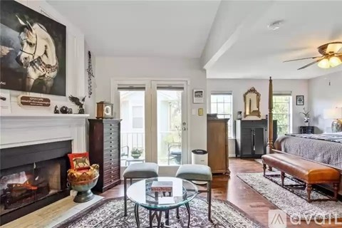 A living room with a fireplace and a painting of a horse on the wall.