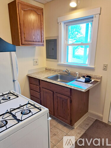 A kitchen with a white stove and wooden cabinets.
