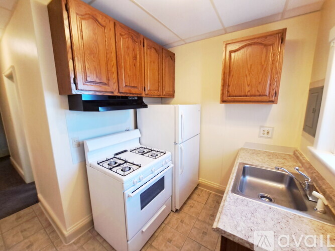 A kitchen with a white stove and white refrigerator.