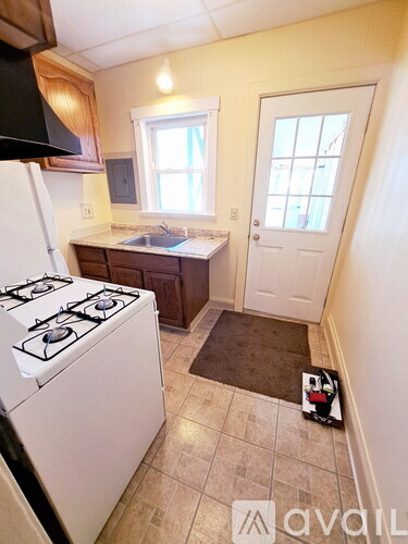 A kitchen with a white stove and a window.