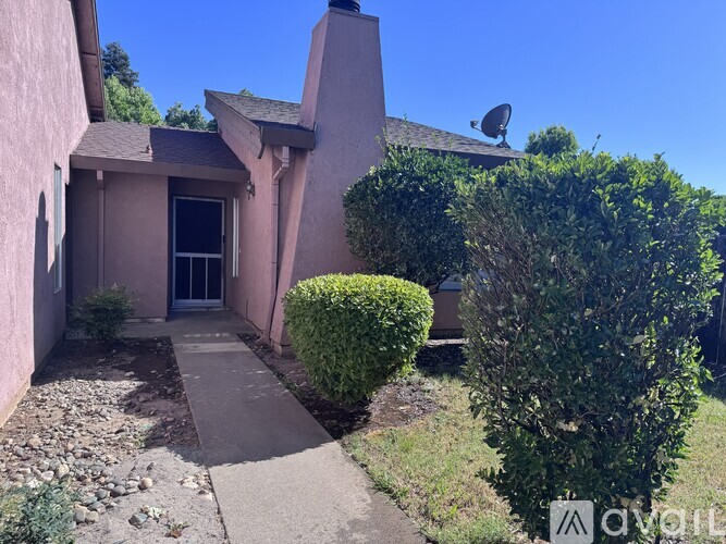 A house with a pink exterior and a satellite dish on the roof.