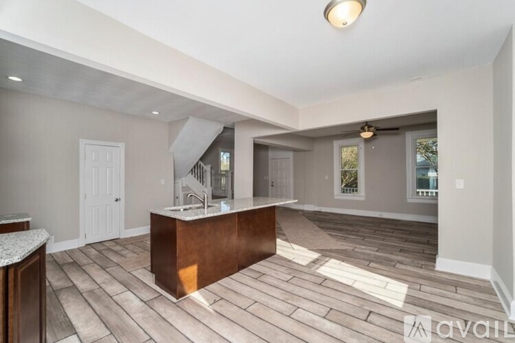 A spacious living room with a central island and hardwood flooring.