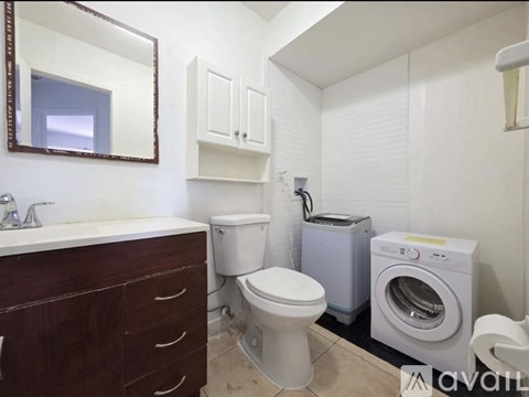 A bathroom with a toilet, sink, and washing machine.