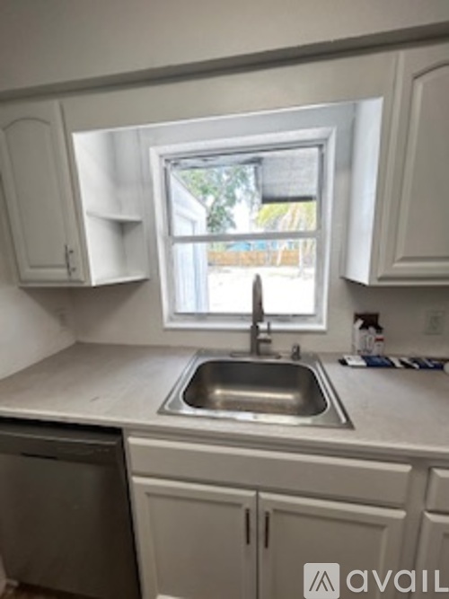 A kitchen with a window above the sink.