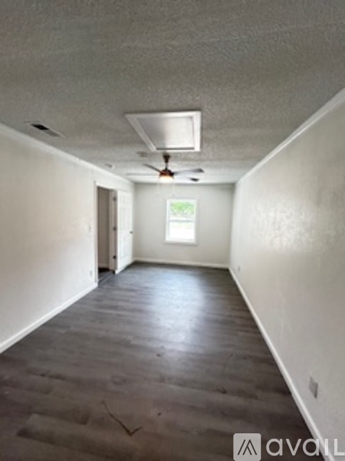 A room with a window and a fan on the ceiling.