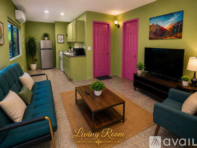 A living room with a green couch, a pink door, and a wooden coffee table.