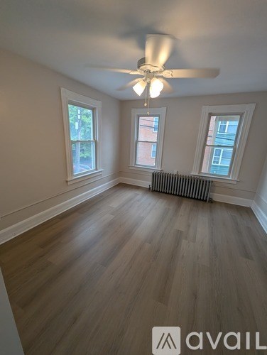 A room with wooden flooring and a ceiling fan.