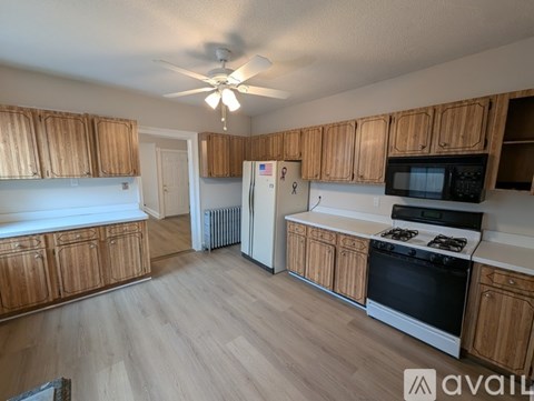 A kitchen with wooden cabinets and a black stove top oven.