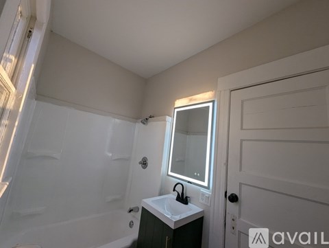A bathroom with a white sink and a mirror.