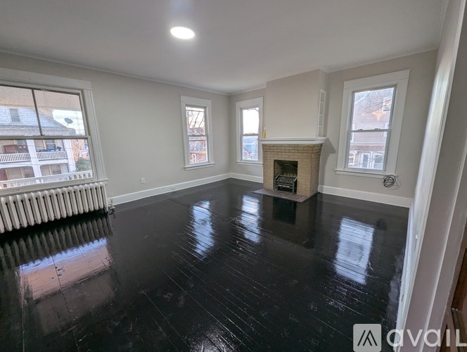 A spacious room with a fireplace and large windows.