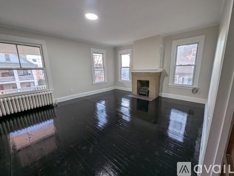 A spacious room with a fireplace and large windows.