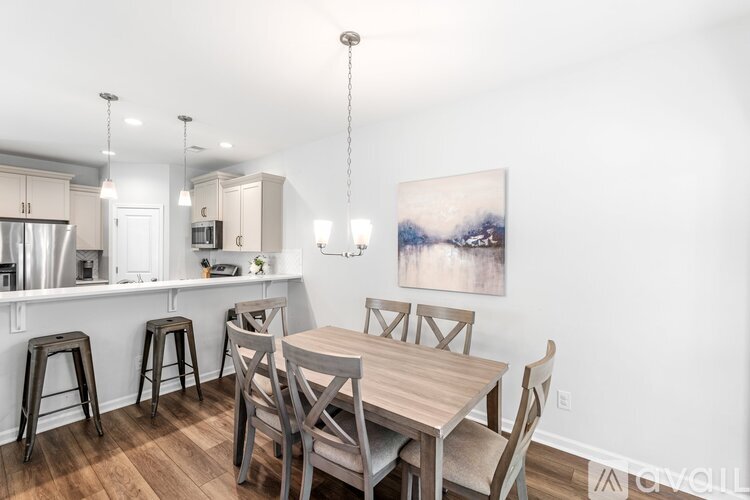 A dining room with a wooden table and chairs.
