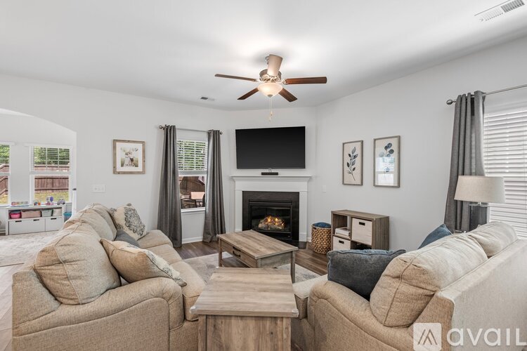 A living room with a fireplace, two couches, and a television.