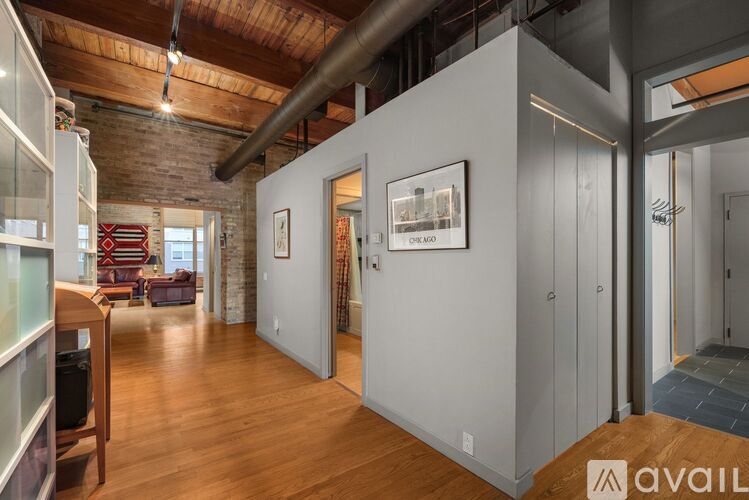 A spacious room with wooden floors and a brick wall.
