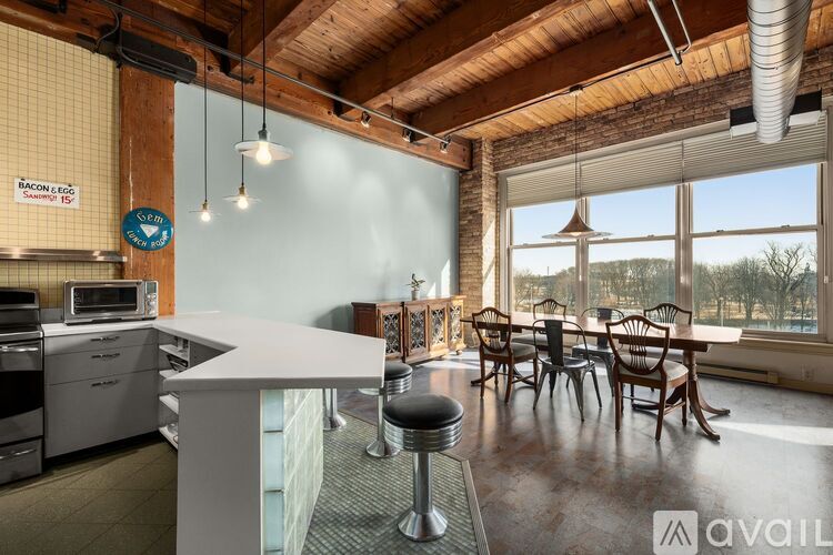 A kitchen with a white counter and a bar stool.