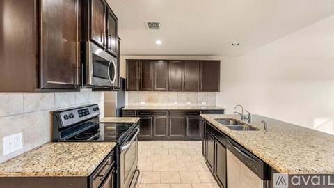 A kitchen with brown cabinets and a granite countertop.