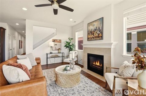A living room with a fireplace and a painting on the wall.