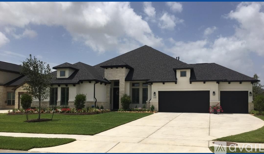 A large, two-story house with a black roof and white trim.