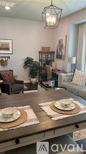 A living room with a wooden table set for two.