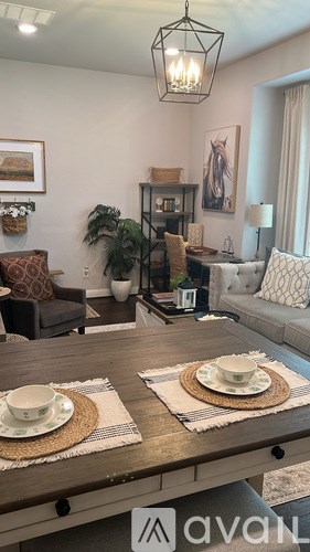 A living room with a wooden table set for two.