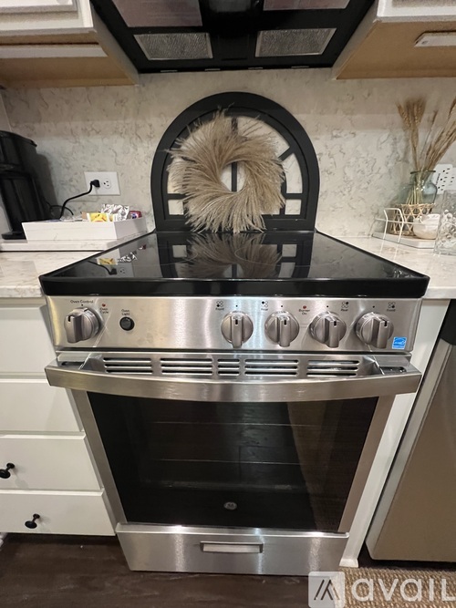 A modern kitchen with a stainless steel oven and a black countertop.