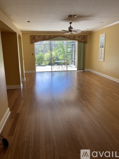 A room with wooden floors and a ceiling fan.