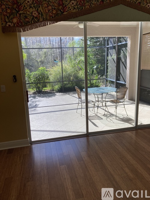 A patio with a table and chairs is visible through a sliding glass door.