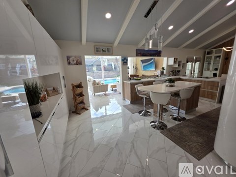 A modern kitchen with white cabinets and a marble floor.
