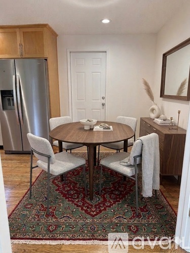 A dining room with a round table and chairs.