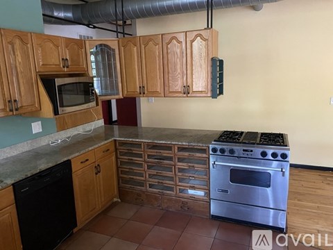 A kitchen with wooden cabinets and a stainless steel oven.