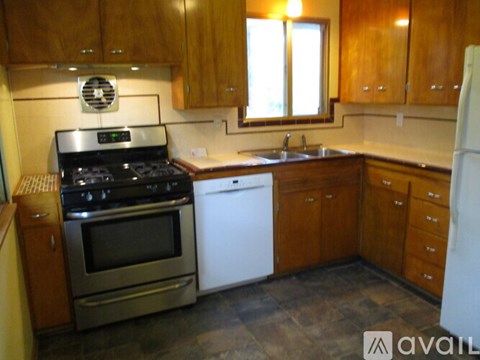 A kitchen with wooden cabinets and a white dishwasher.