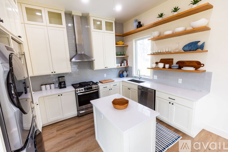 A kitchen with white cabinets and a white island.