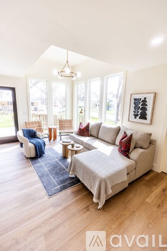 A living room with a grey couch and a blue rug.