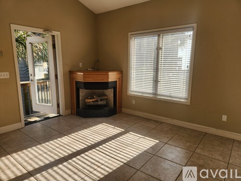 A room with a fireplace and a window with blinds.
