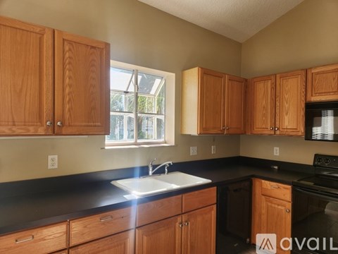 A kitchen with wooden cabinets and black countertops.