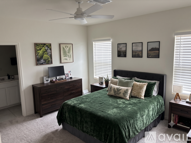 A bedroom with a bed, dresser, and ceiling fan.