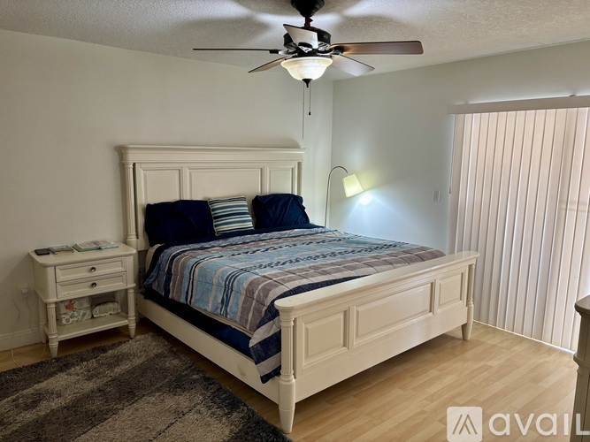 A bedroom with a large bed and a ceiling fan.
